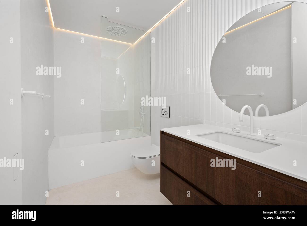 Small bathroom with oversized round mirror above sink Stock Photo - Alamy