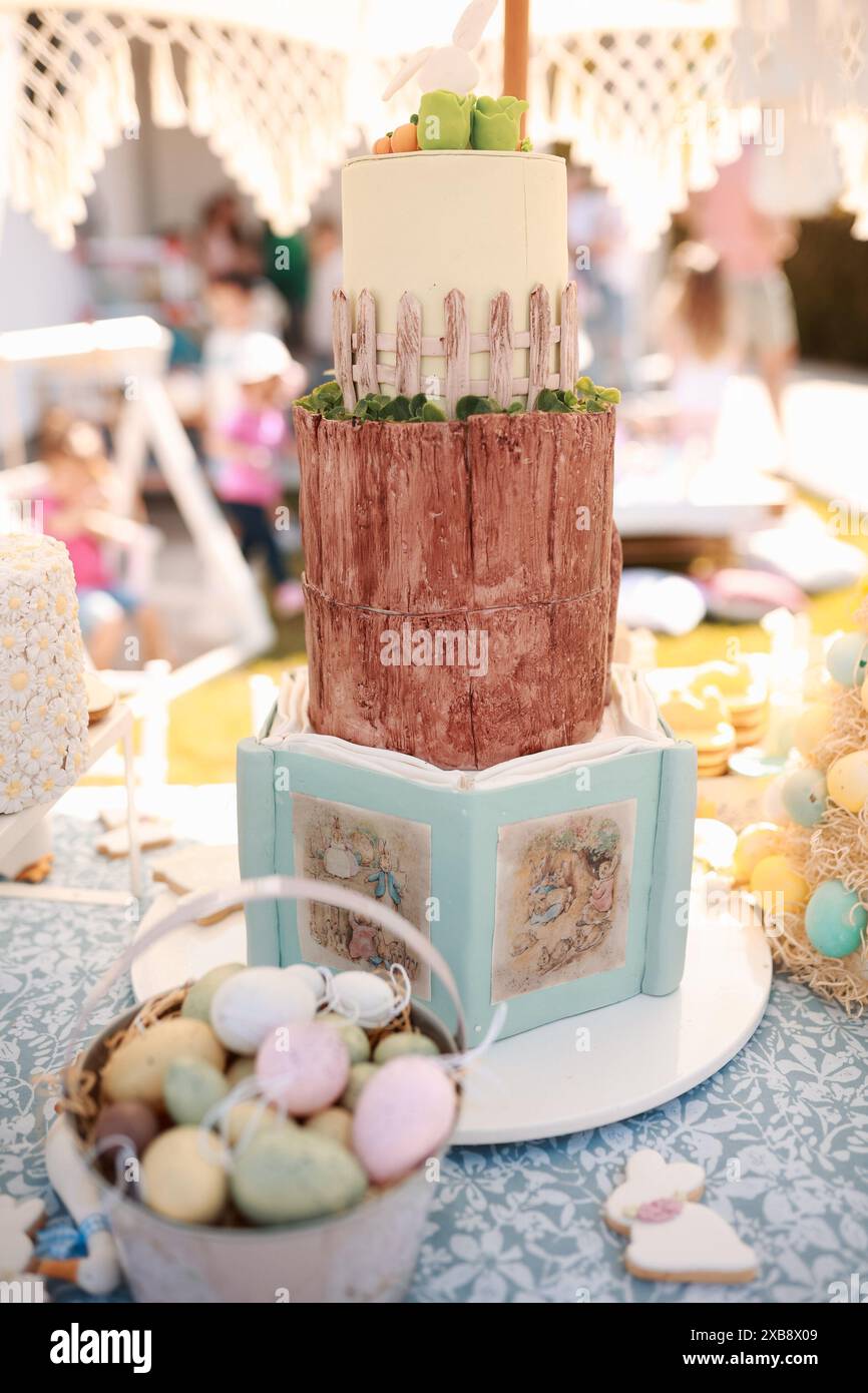 A vertical shot of a festive Easter cake surrounded by colorful eggs Stock Photo