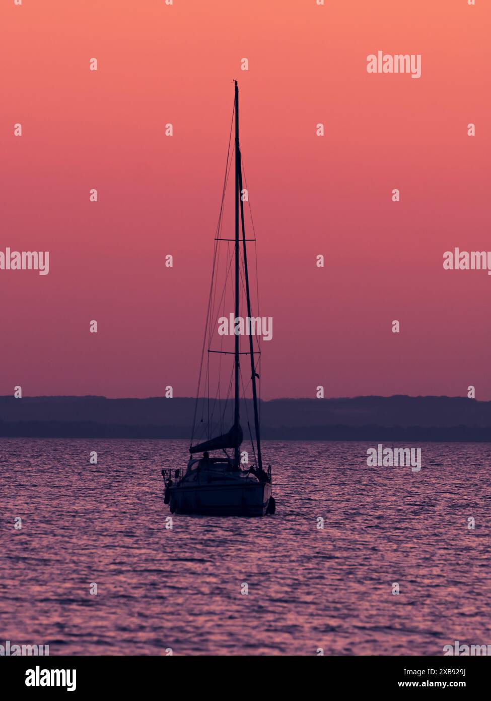The image depicts a serene sailboat on the water during sunset Stock ...
