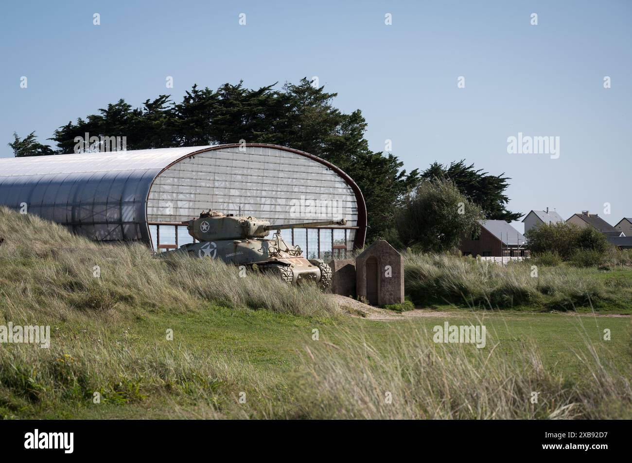 An old M4 Sherman tank peeking out of the hills at Utah Beach Museum Stock Photo