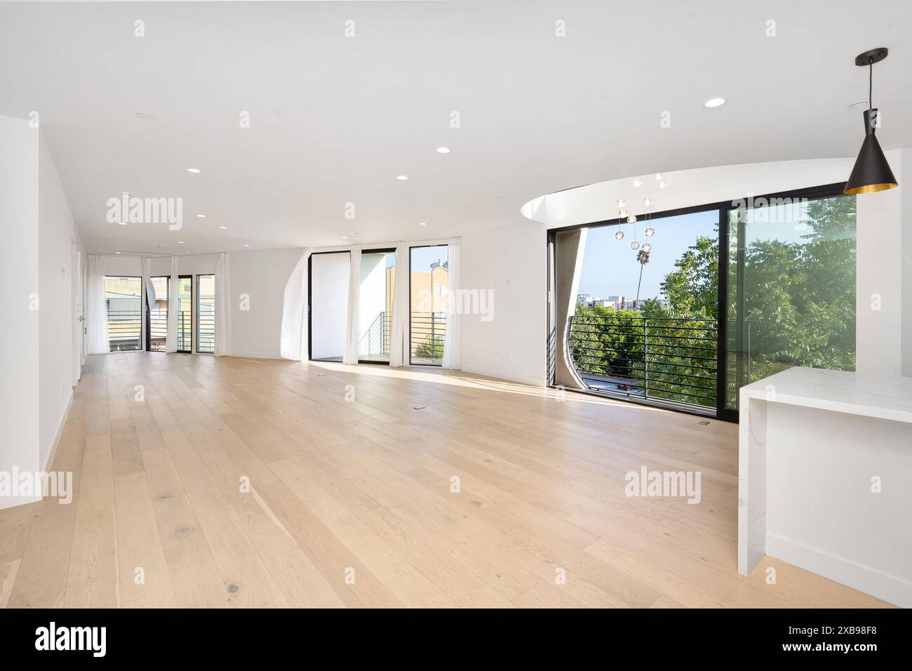 A spacious room with an open layout and light wood flooring. California ...