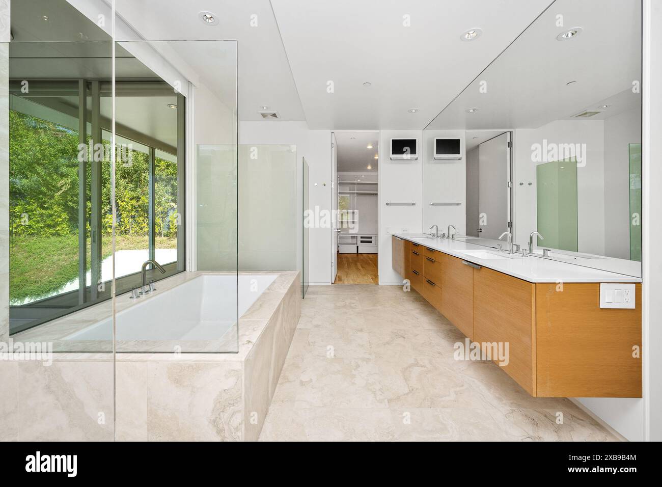A spacious bathroom featuring a bathtub, vanity, and shower Stock Photo