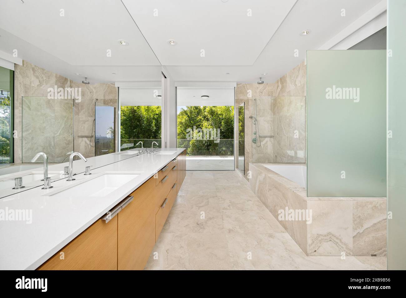 A spacious bathroom with dual sinks and modern walk-in shower Stock Photo