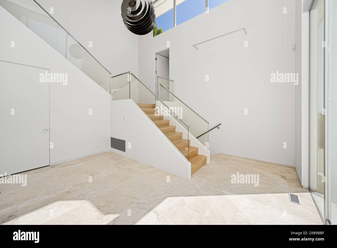 The interior of contemporary white house with curved glass railings and ...