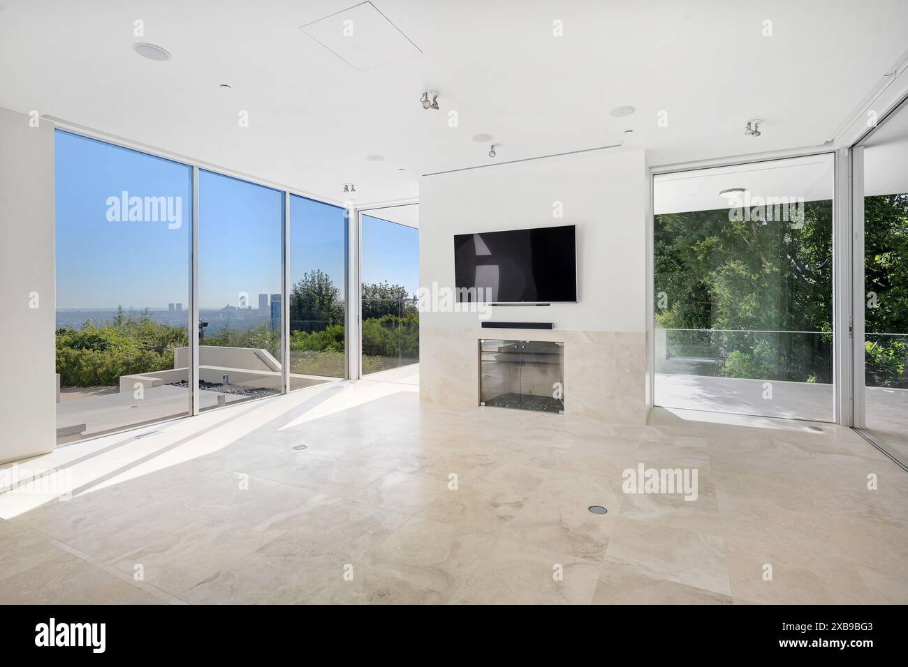 A minimalist living room with a wall-mounted flat screen TV Stock Photo ...
