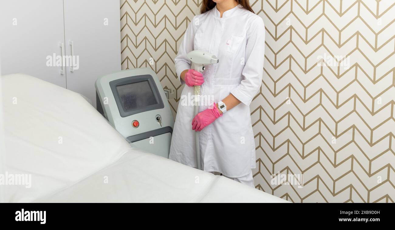 Female dermatologist posing with diode laser hair removal tool. Female doctor, therapist holding