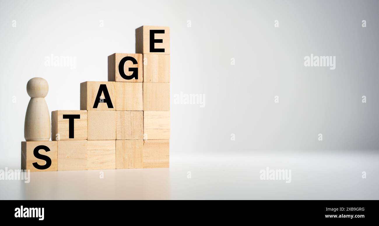 Wooden blocks with "STAGE" text of concept and a human toy Stock Photo ...