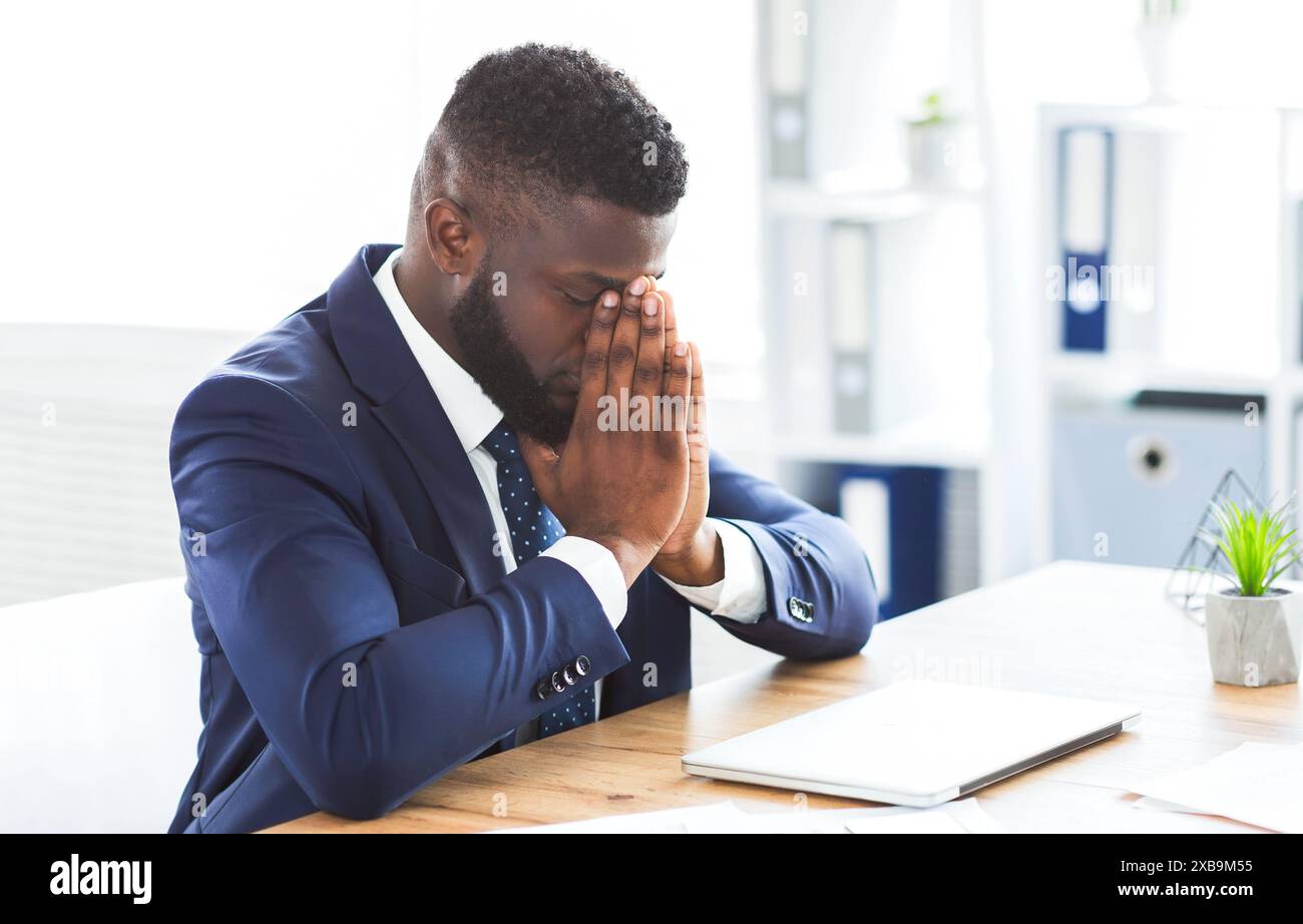 Young tired businessman having stress at work Stock Photo