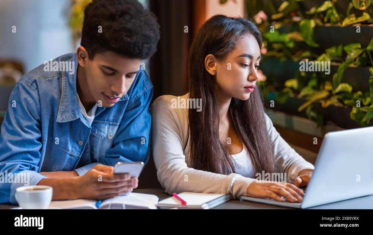 Two Young People Using a Laptop in a Cafe Stock Photo