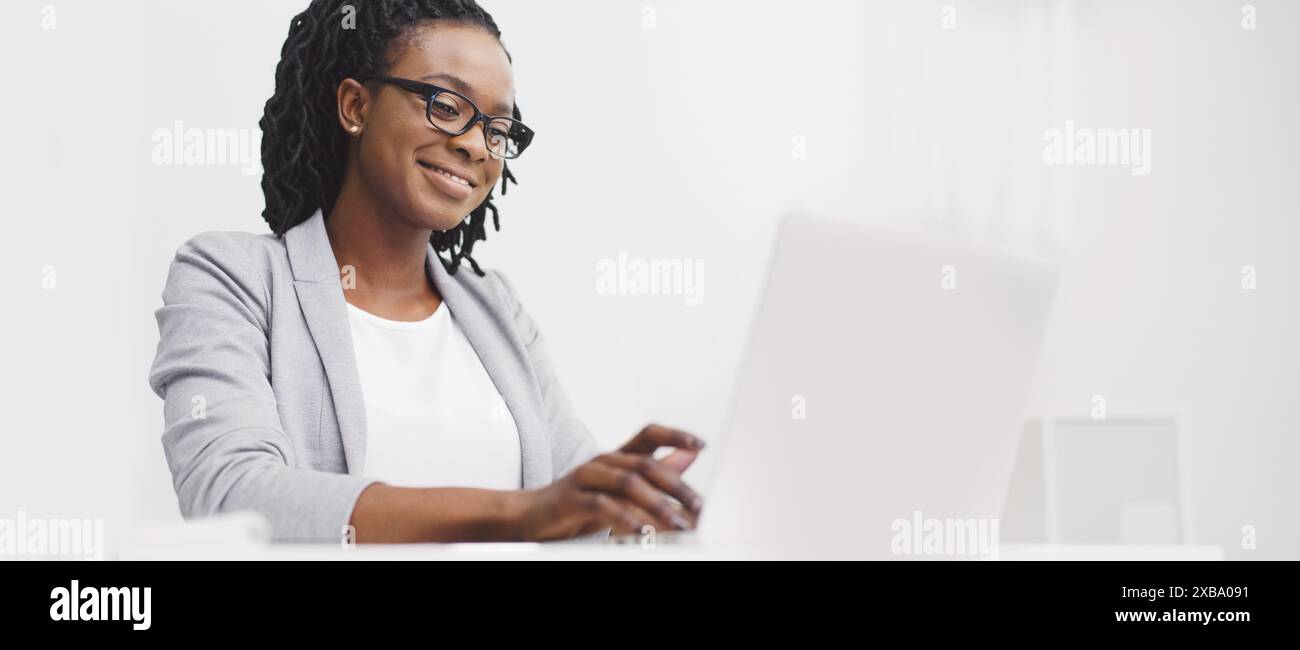 Office employee is focused on her computer at her desk Stock Photo