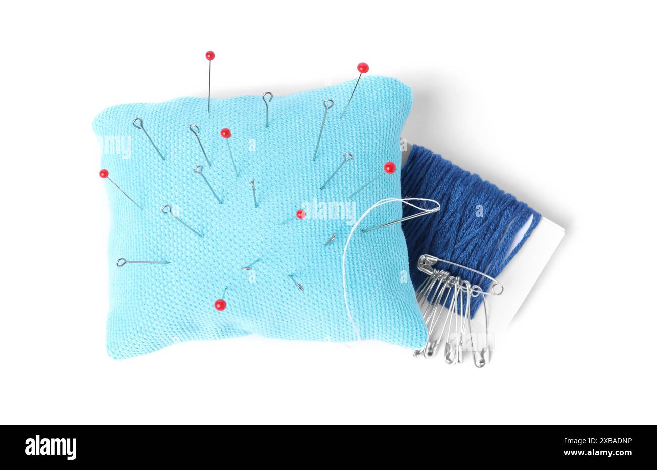 Light blue pincushion with sewing pins and threads isolated on white — free download