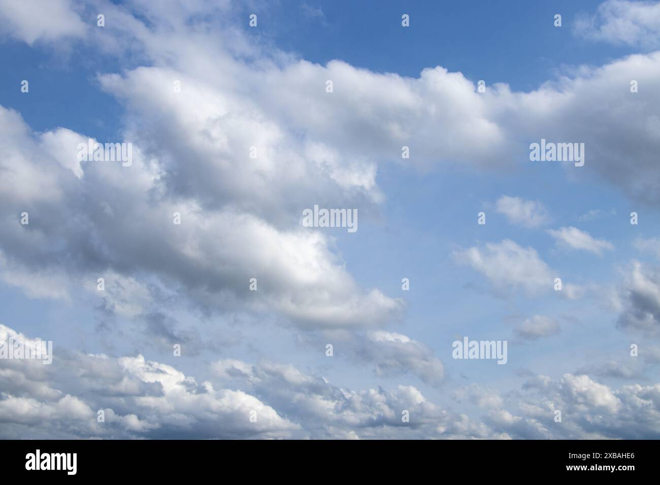 Blue sky with white puffy clouds Stock Photo - Alamy