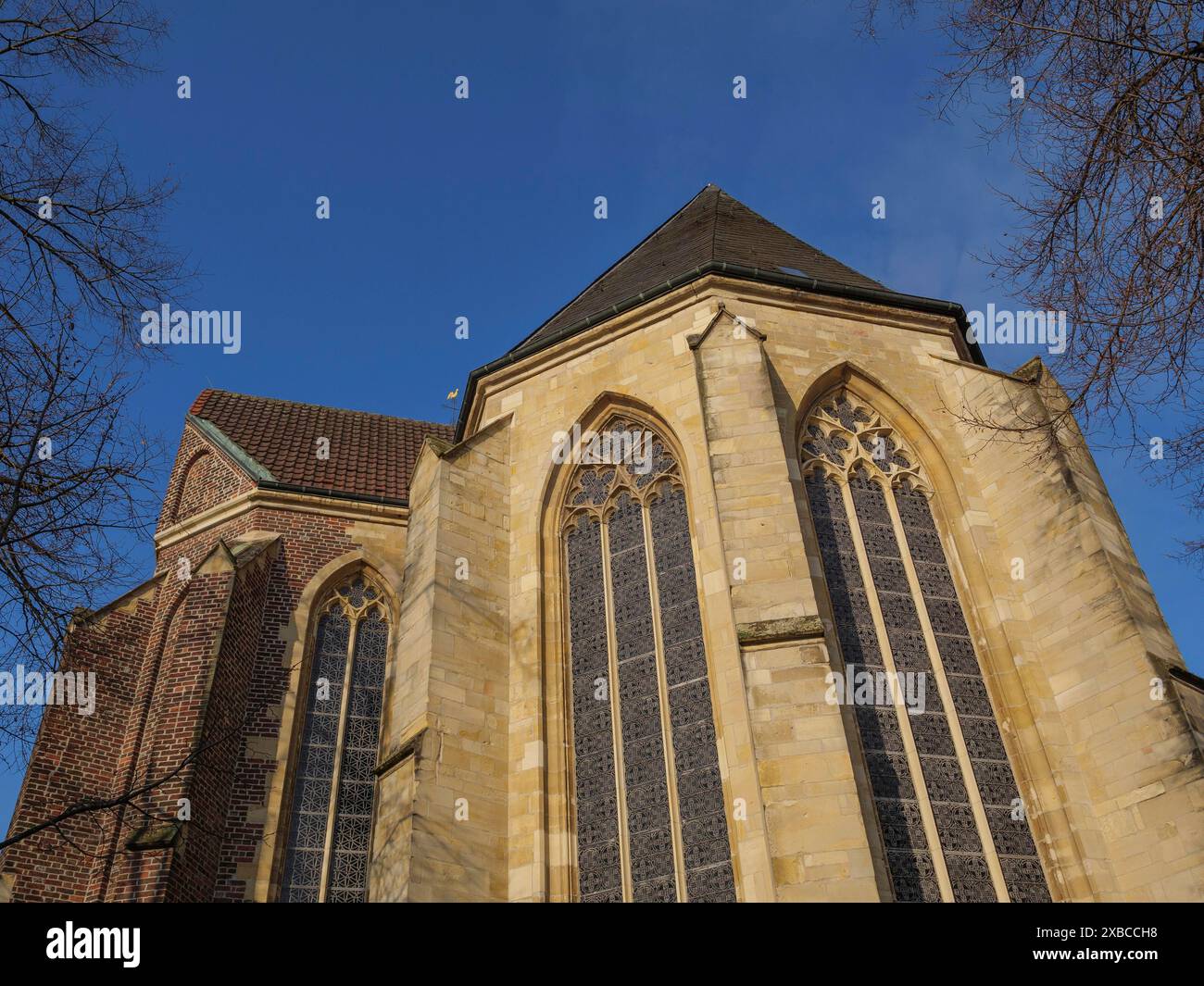 A church with large Gothic windows and a brick facade under a clear blue sky, Coesfeld, Muensterland, North Rhine-Westphalia, Germany Stock Photo