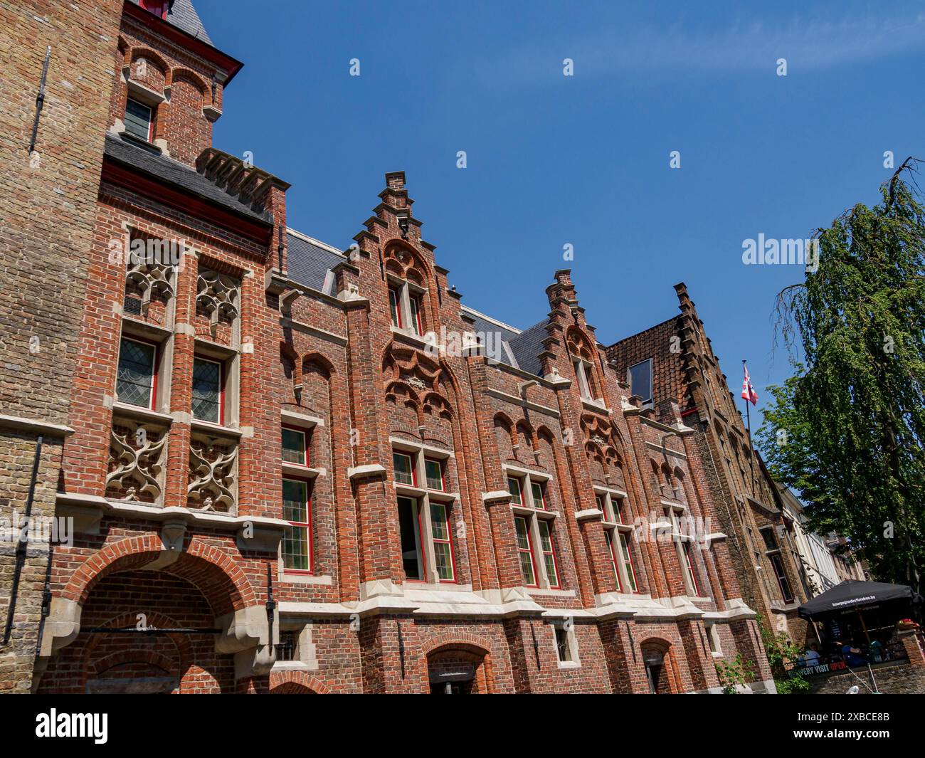 Historic brick building with many windows and a red roof under a blue ...