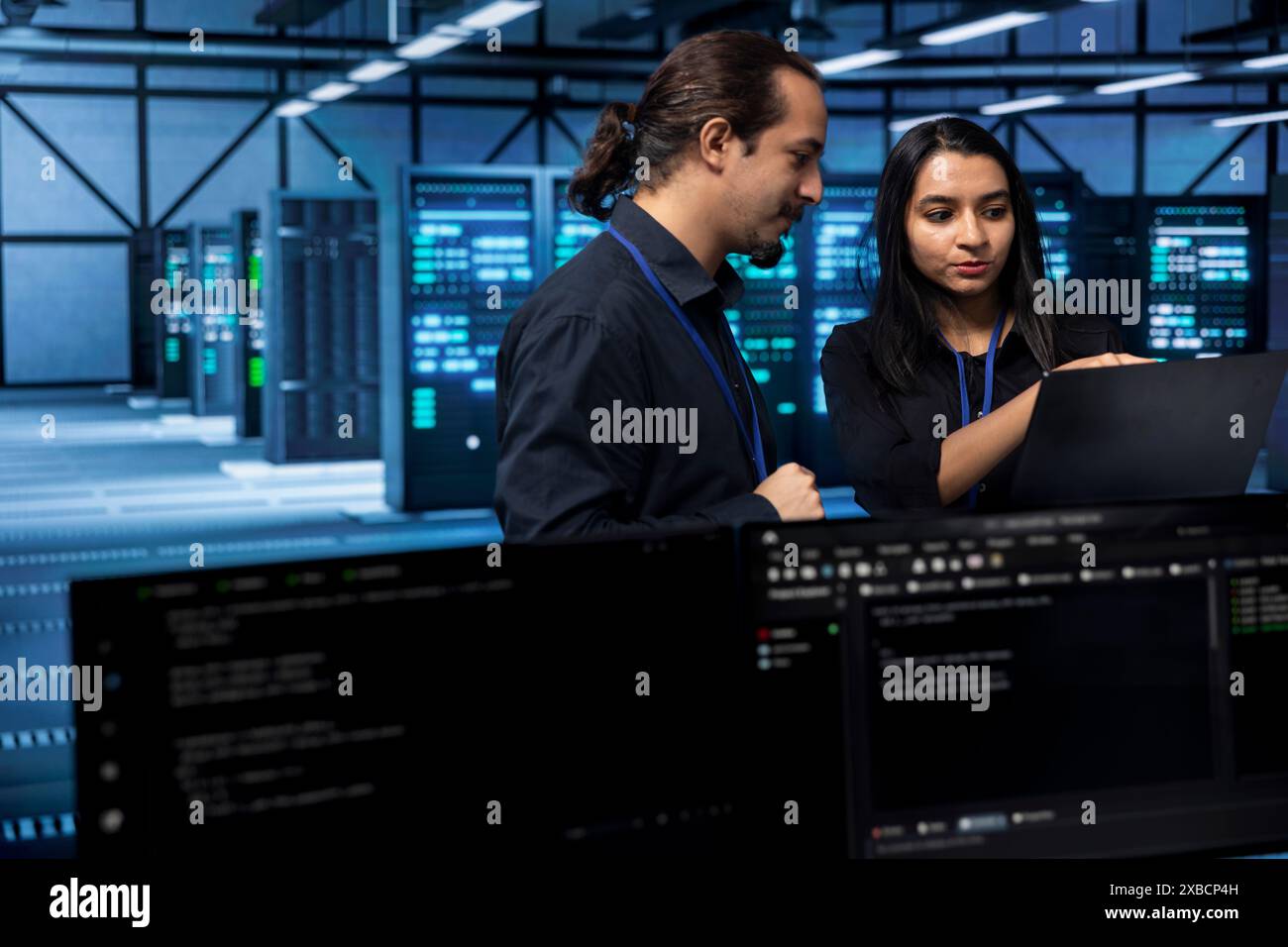 Software developers in data center running system diagnostic tests on laptop to fix problems. IT staff members deploying and error checking utilities on notebook to fix network issues performance Stock Photo