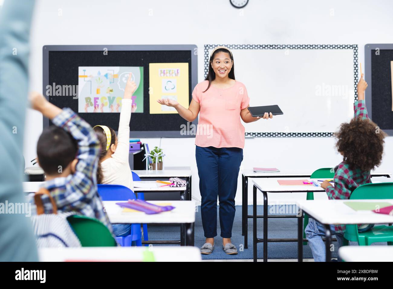 Biracial female teacher engaging with students in classroom Stock Photo ...