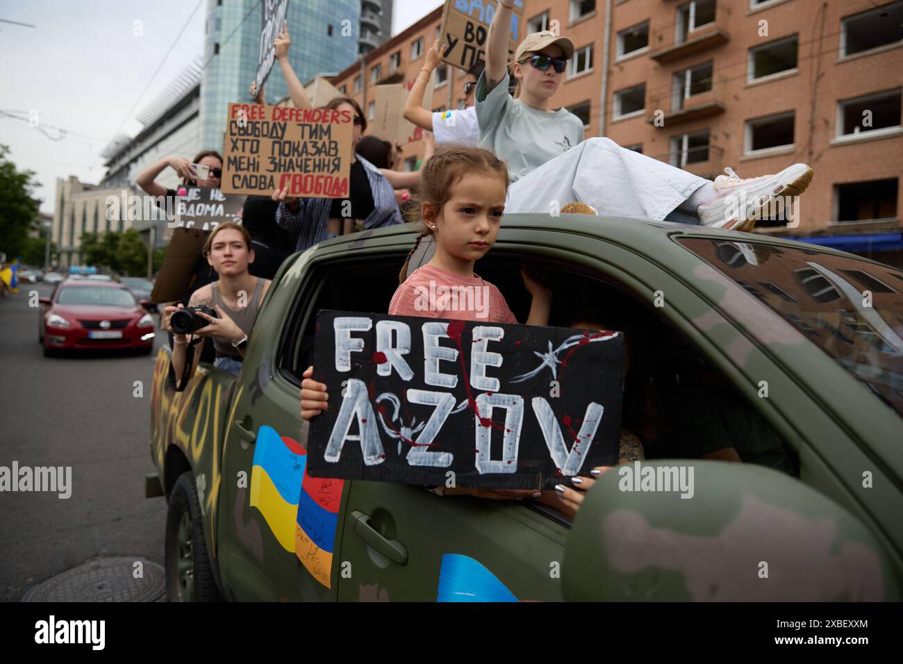 Ukrainian girl rides in a military pickup truck with a sign Free Azov ...