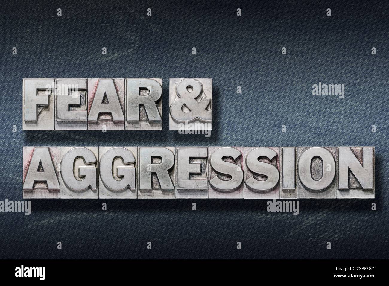 fear and aggression phrase made from metallic letterpress on dark jeans background Stock Photo