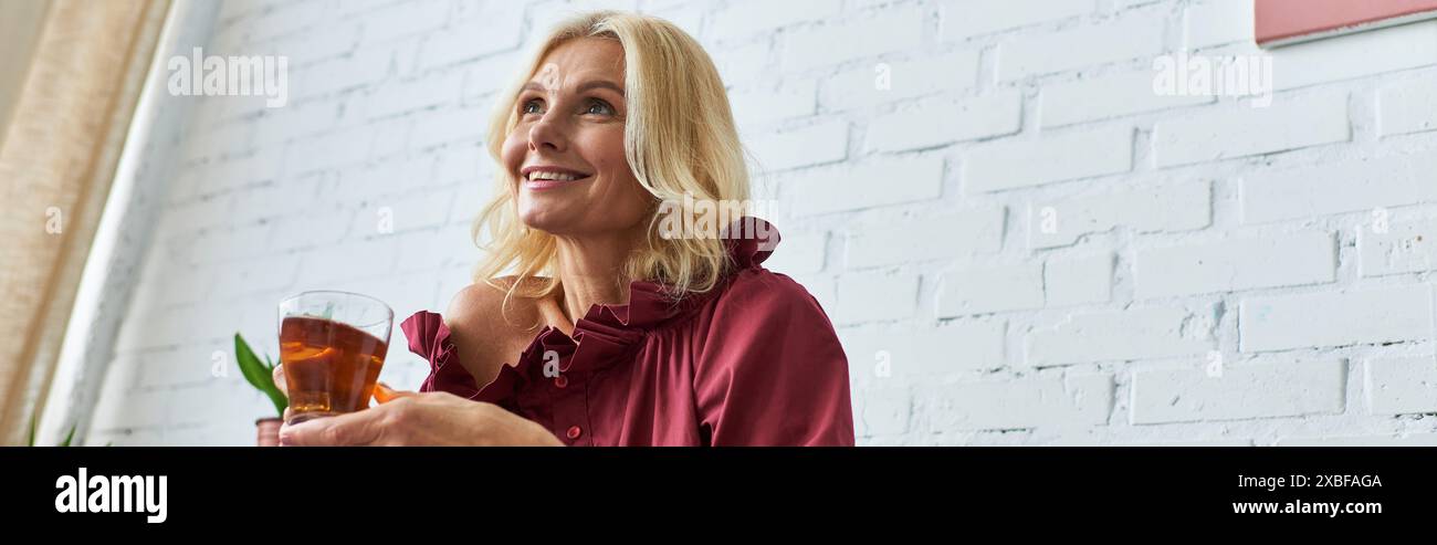 Stylish woman in red shirt holding a drink. Stock Photo