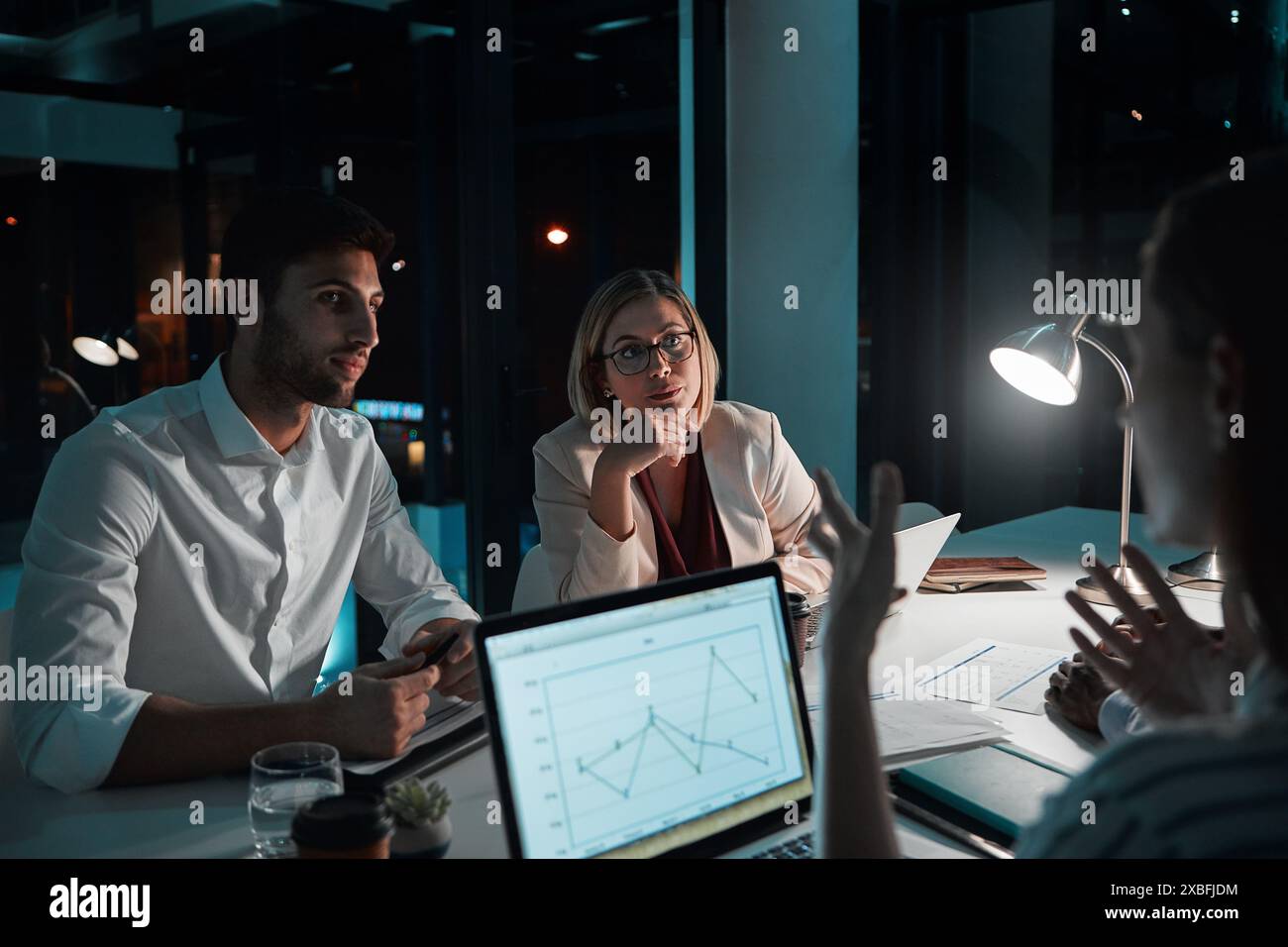 Employee, teamwork and laptop in office at night with documents for ...