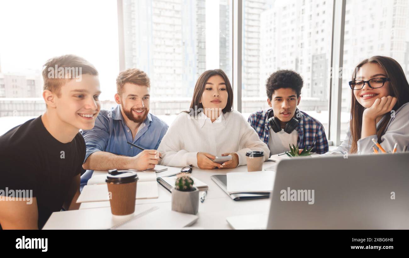 Skilled young programmers watching webinar on laptop computer Stock Photo