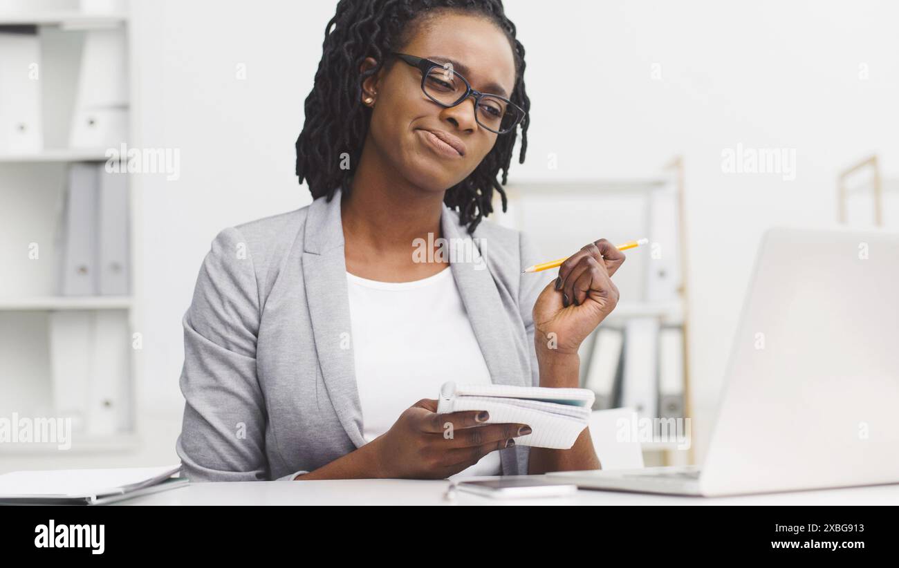 Thoughtful African American lady working on report Stock Photo