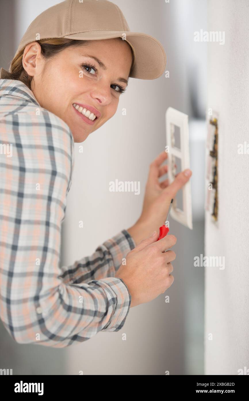 female builder installing triple switch box on the wall Stock Photo - Alamy