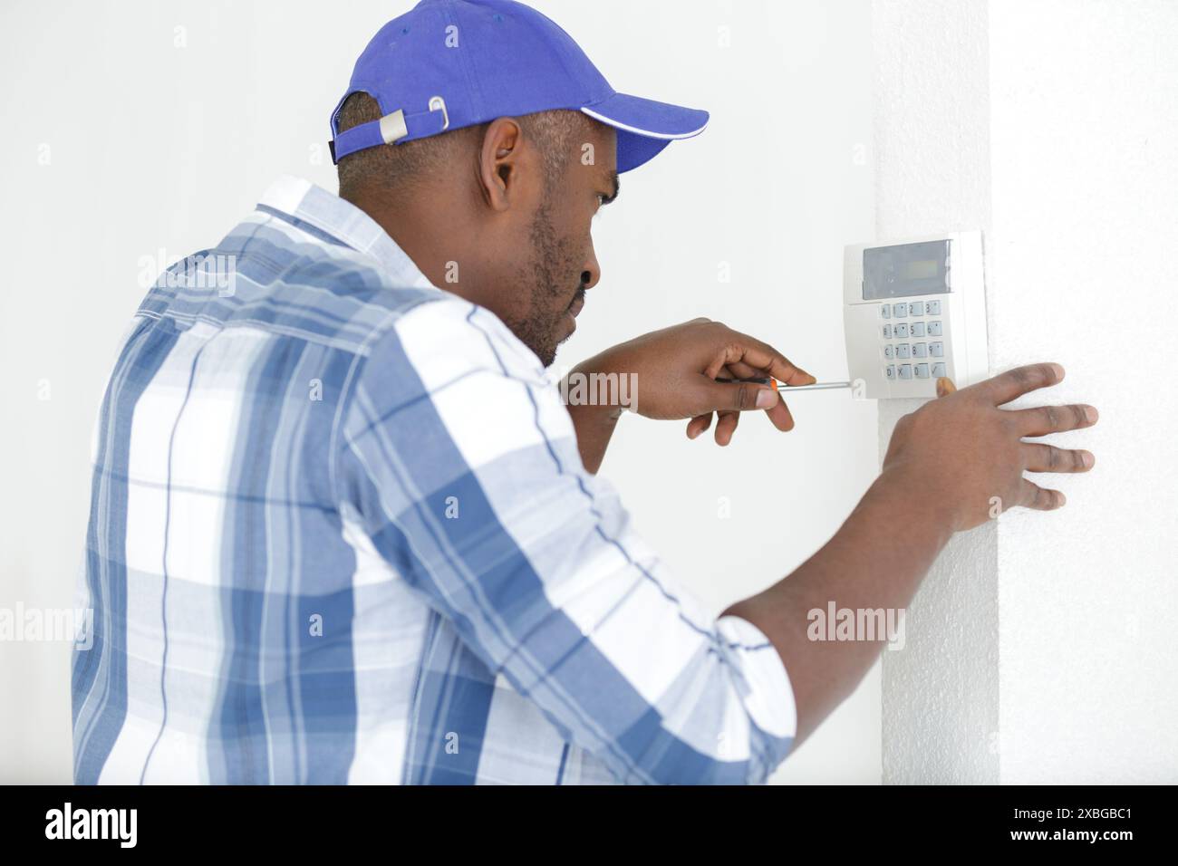 male technician installing security system using screwdriver Stock Photo