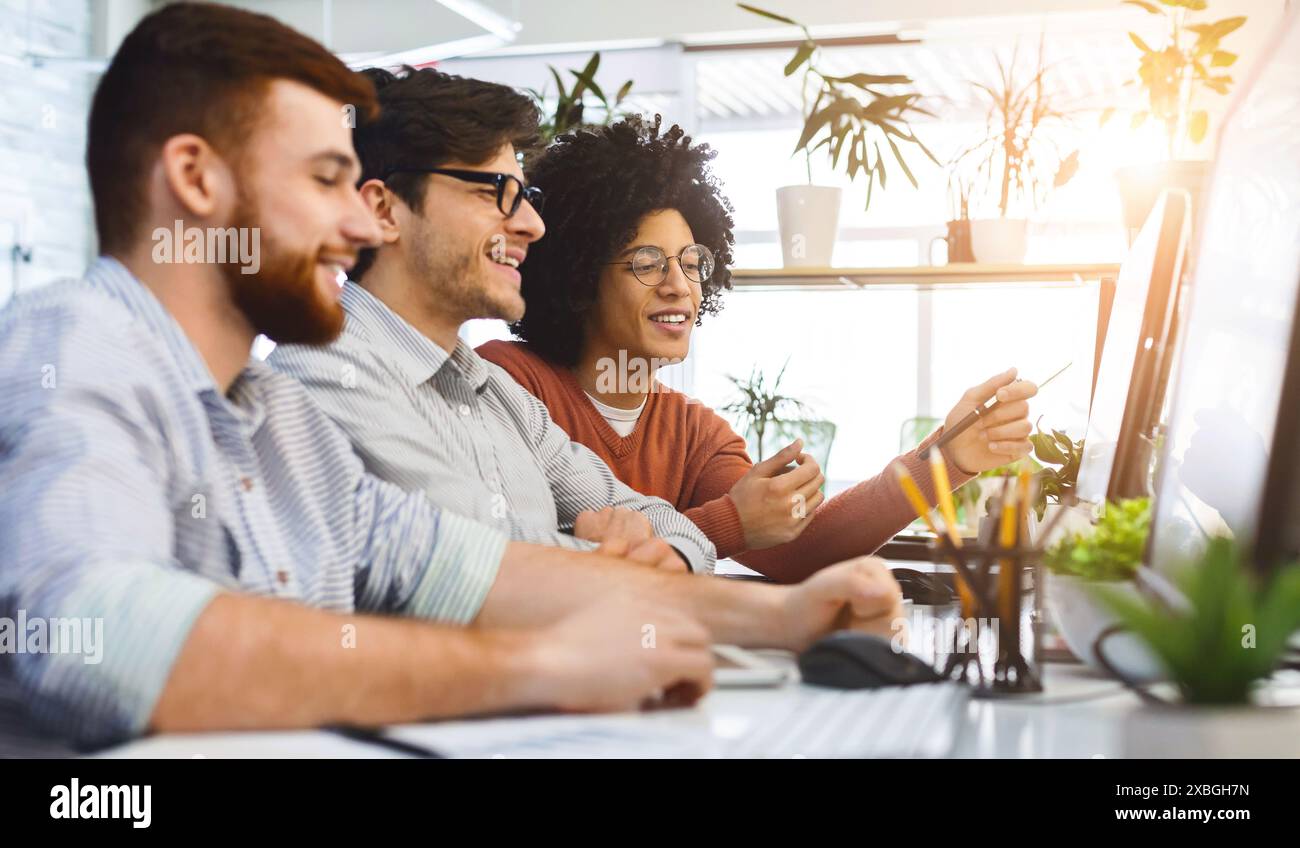 Programmers cooperating at IT company developing apps Stock Photo