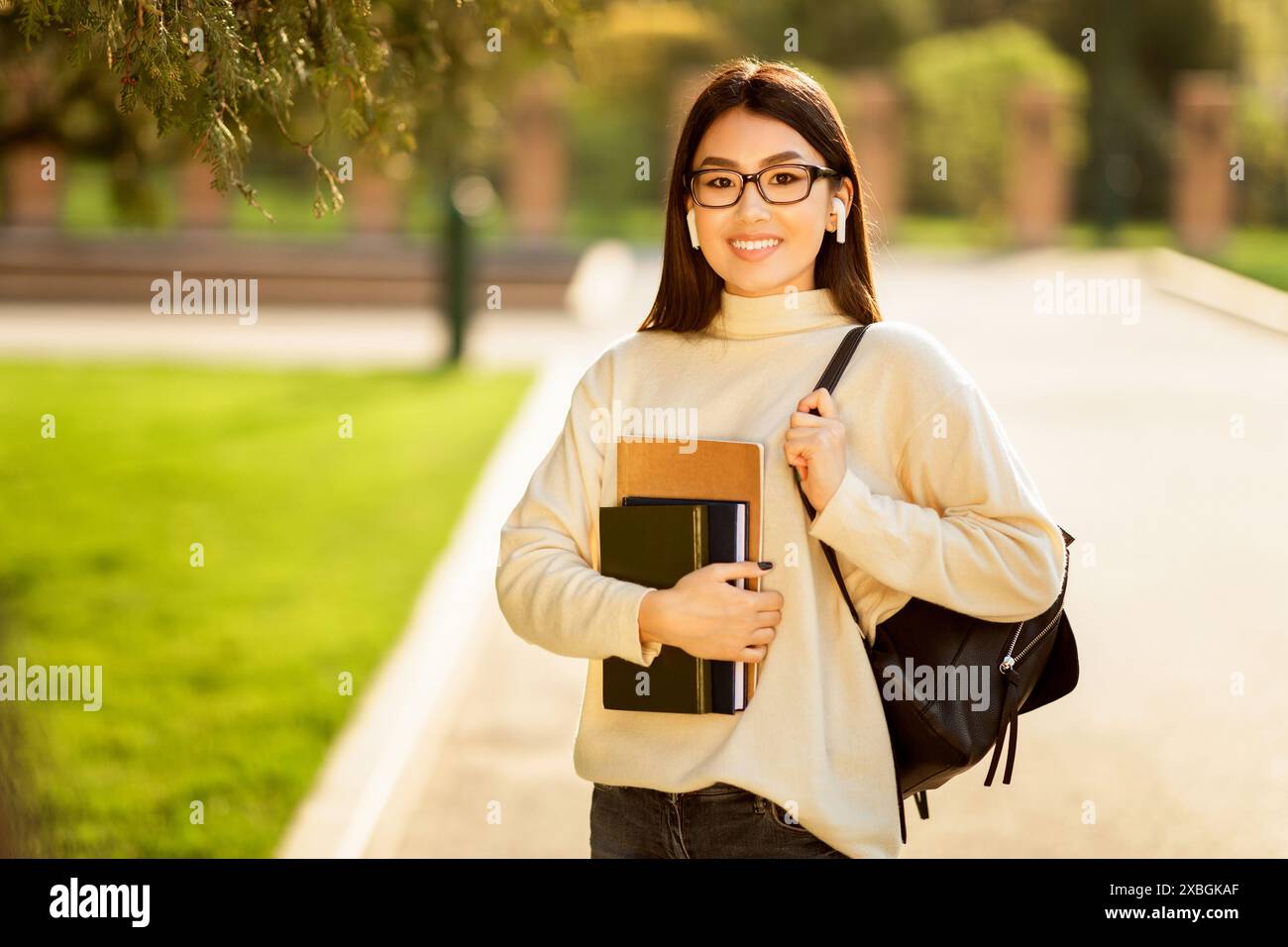 Asian Woman Student Holding Book and Backpack Stock Photo - Alamy