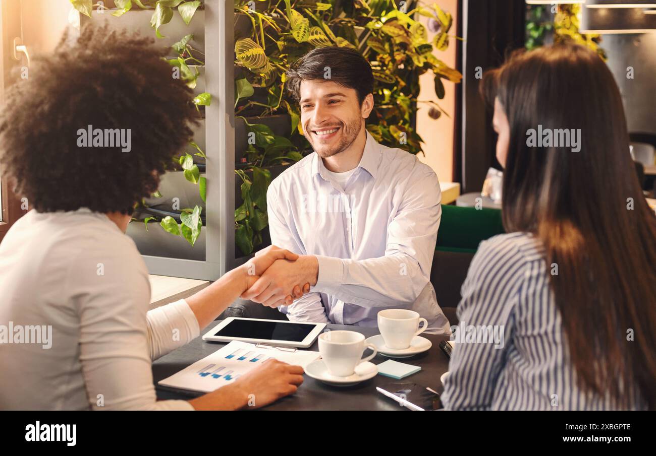 Handshake of businessmen during lunch break in cafe Stock Photo