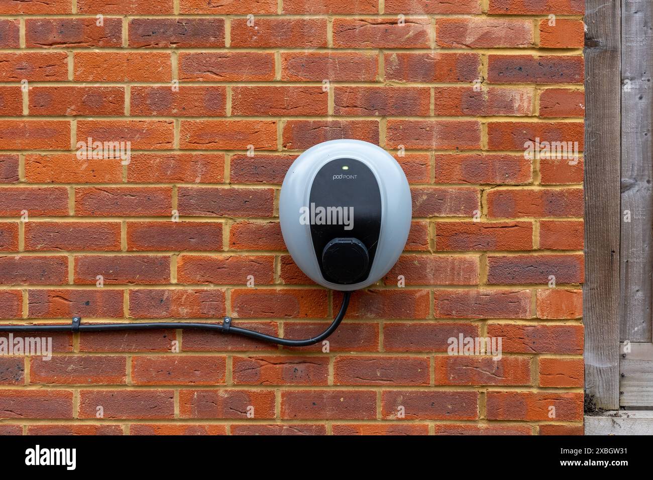 Electric car charger on brick wall. EV Stock Photo