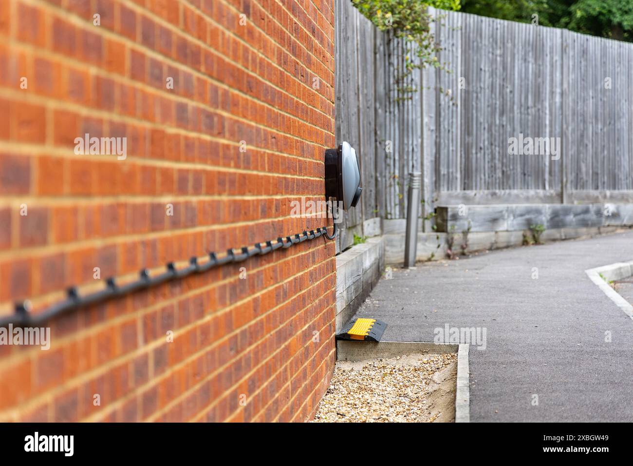 Electric car charger on brick wall. EV Stock Photo