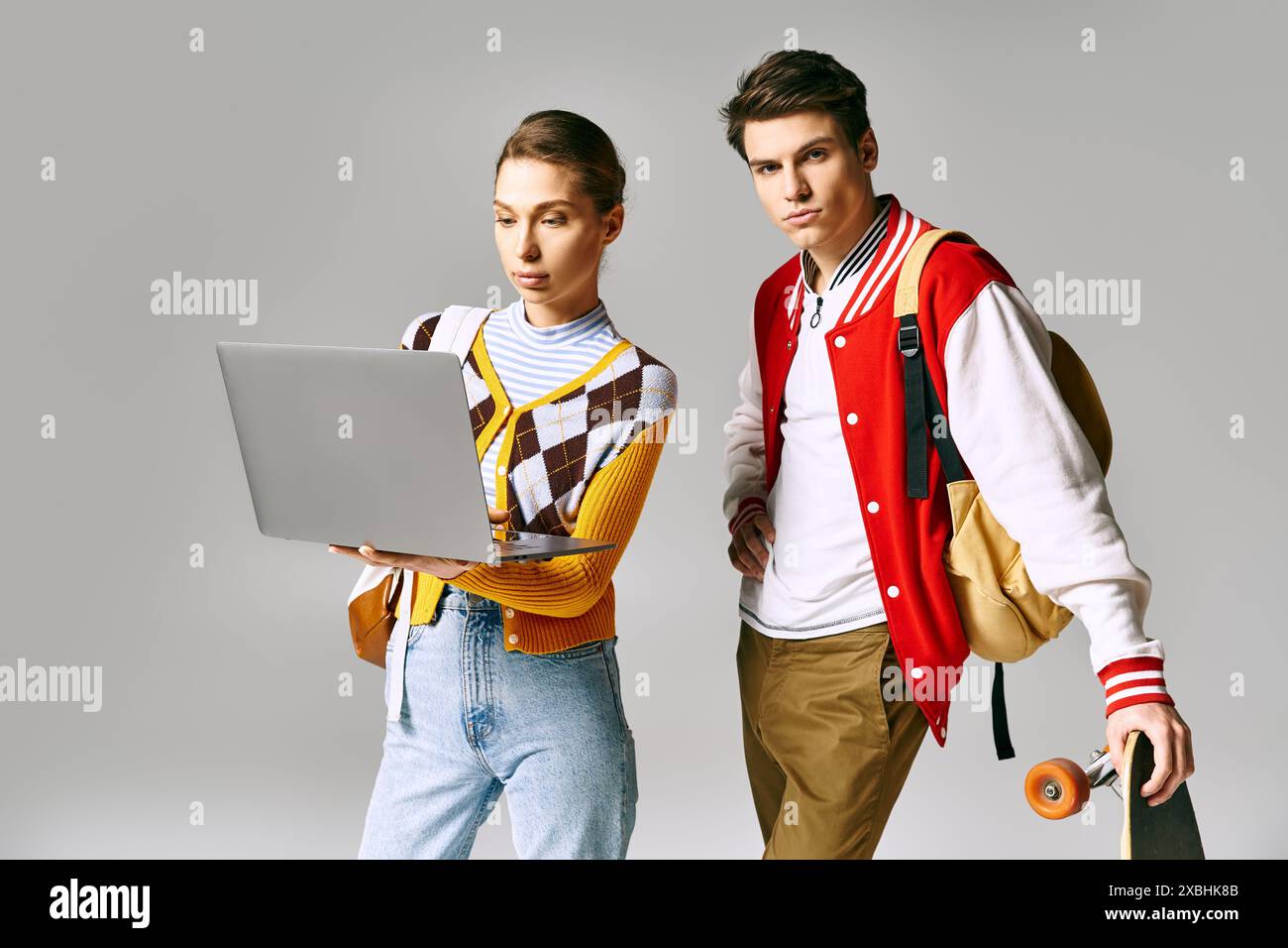 Casual college duo with laptop and skateboard. Stock Photo