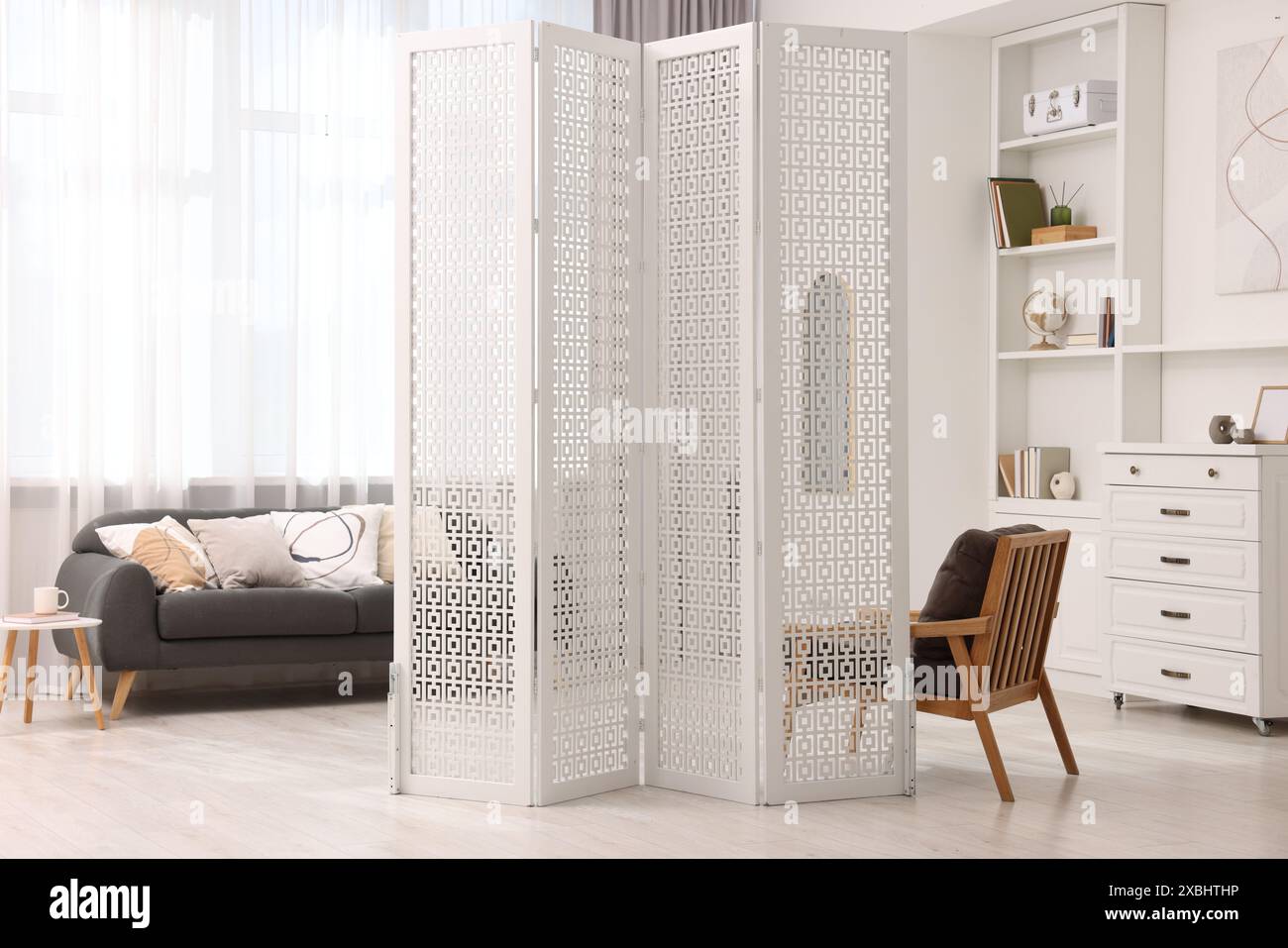 White folding screen, armchair, sofa and side table in living room ...