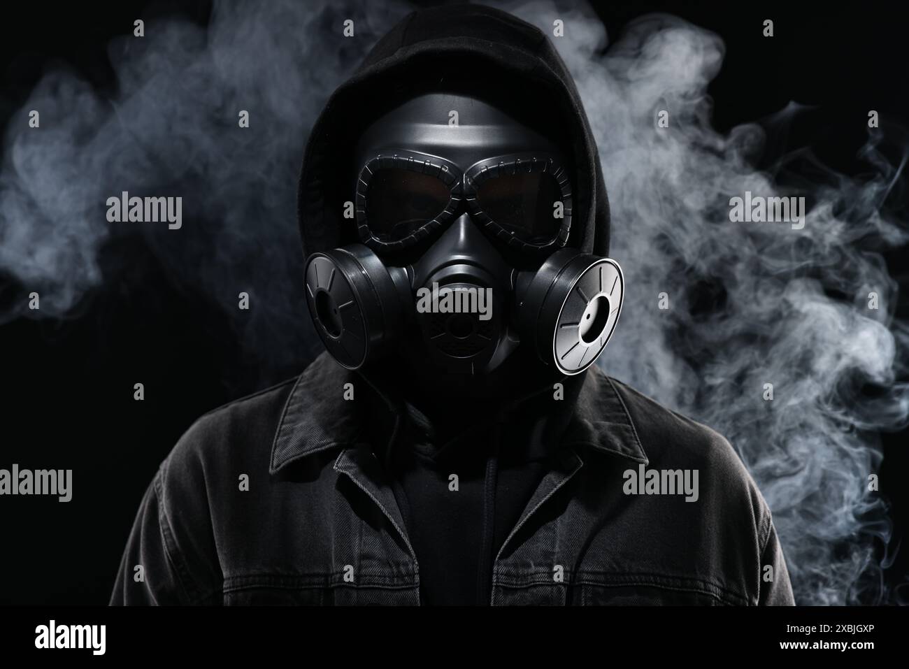 Man wearing gas mask in smoke on black background Stock Photo - Alamy