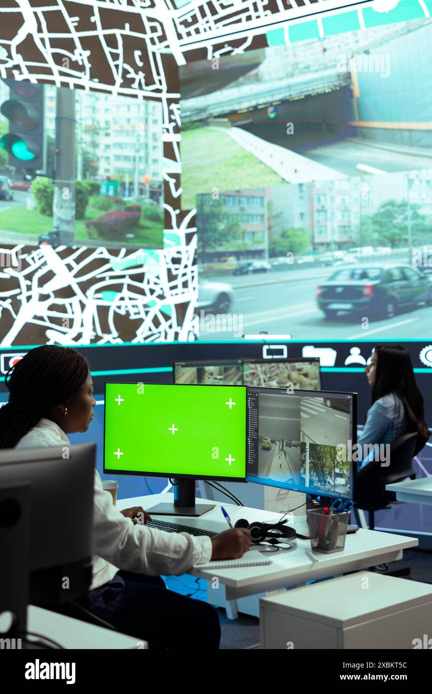 African american woman operator monitoring couriers in traffic via CCTV ...