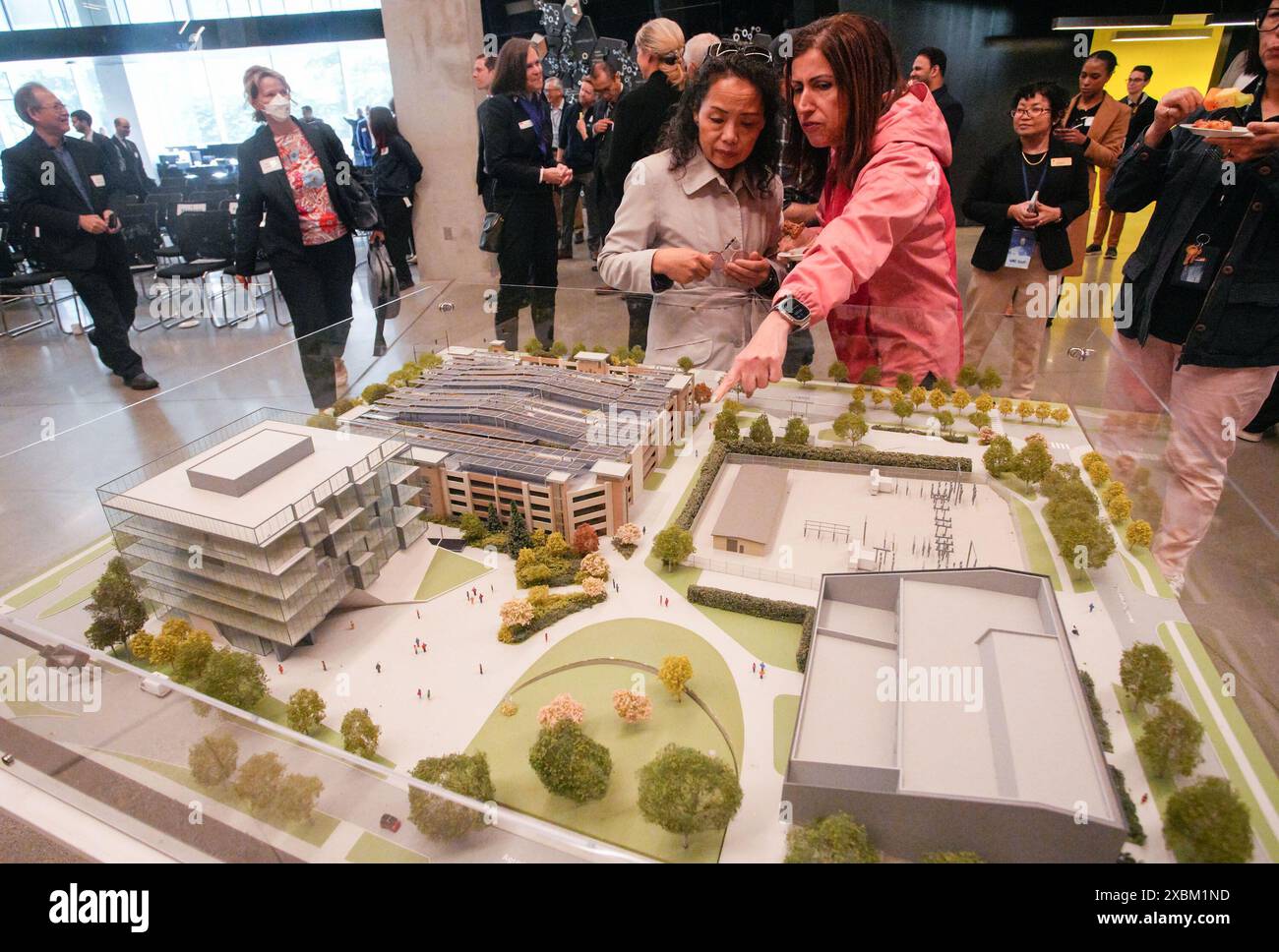 Vancouver, Canada. 12th June, 2024. People look at the scaled model of the Smart Hydrogen Energy District at the University of British Columbia in Vancouver, British Columbia, Canada, on June 12, 2024. Canada's first facility to combine hydro, solar, and hydrogen energy at a single site, the Smart Hydrogen Energy District (SHED), was unveiled at the University of British Columbia's Vancouver campus on Wednesday. Credit: Liang Sen/Xinhua/Alamy Live News Stock Photo