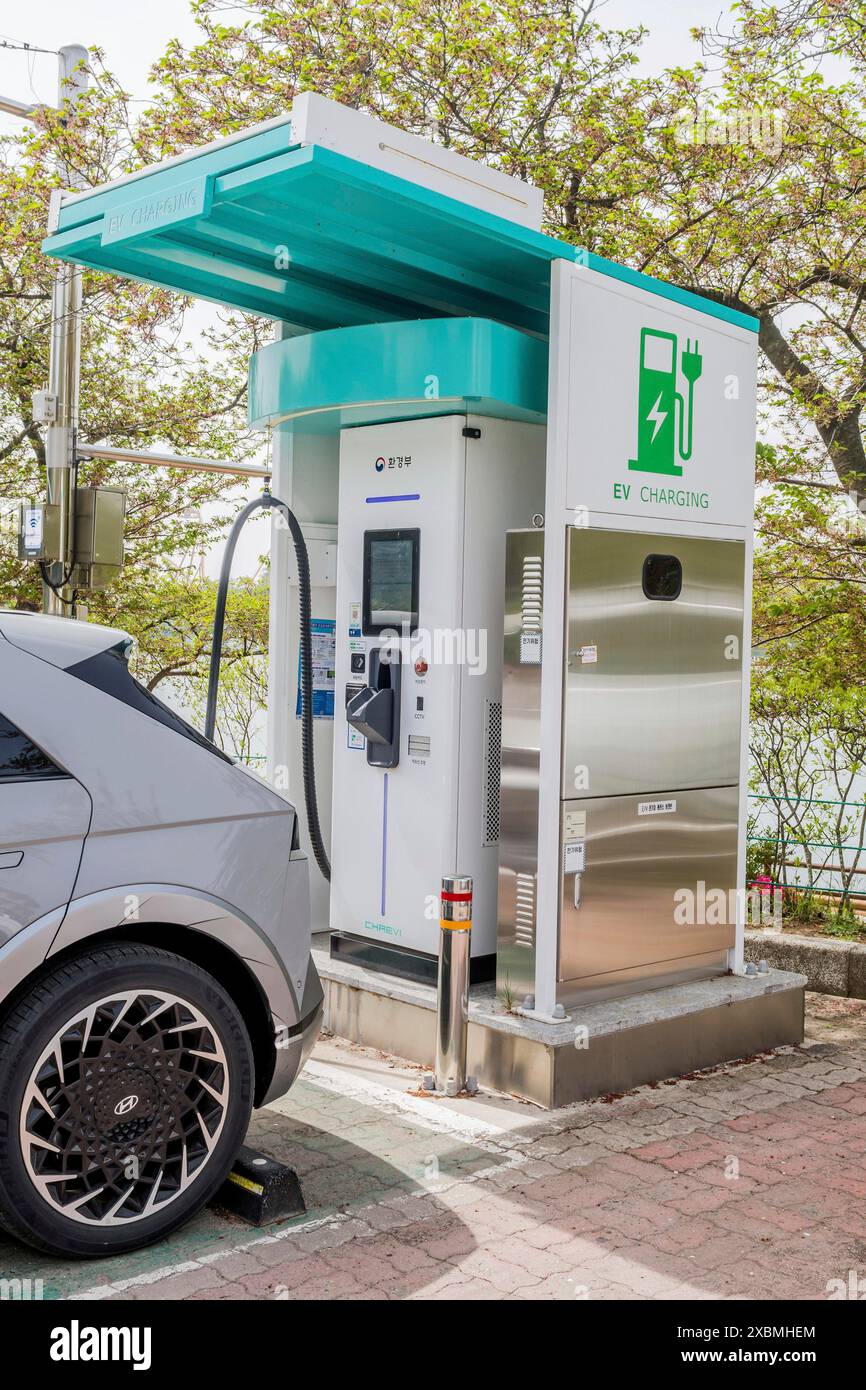 Electric vehicle charging station with a car connected, under a canopy