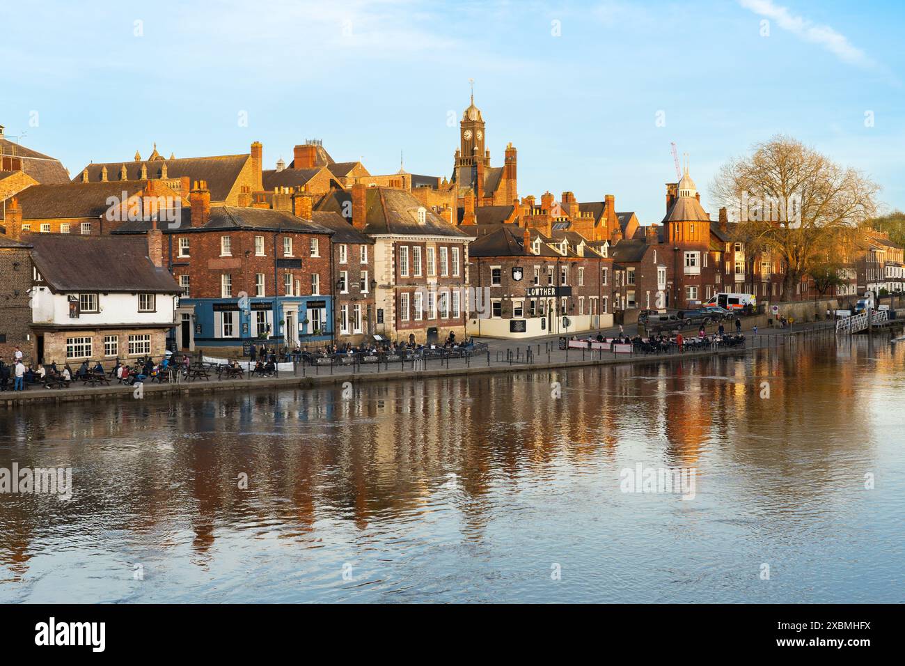 View from the Ouse Bridge of King's Staith and diners and drinkers sitting outside next to the river Ouse in mid spring at sunset, York, UK Stock Photo