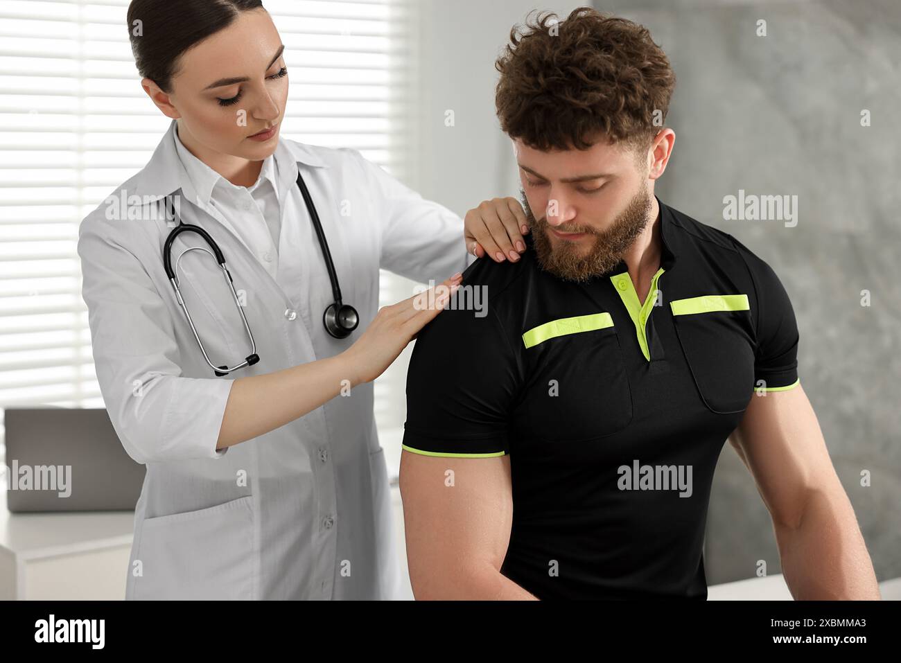 Sports injury. Doctor examining patient's shoulder in hospital Stock ...