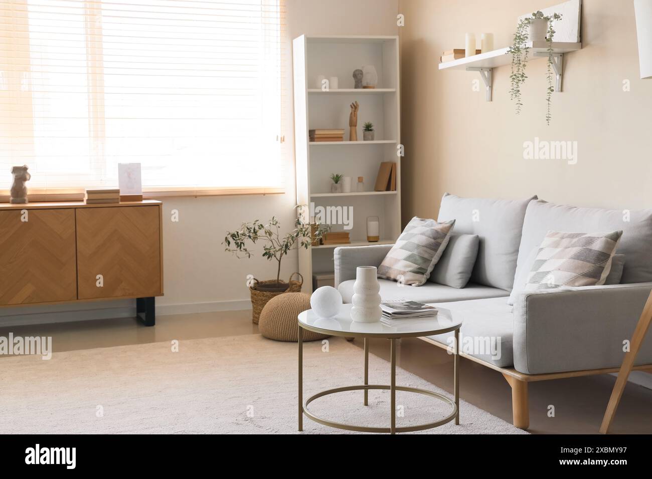 Stylish interior of light living room with cozy couch, coffee table and ...