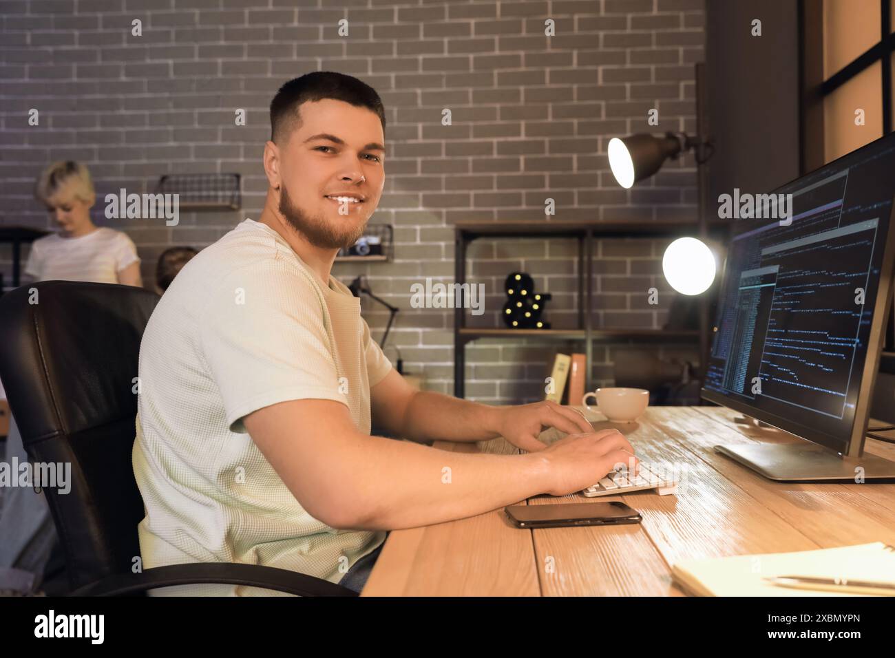 Male programmer working with computer in office at night Stock Photo