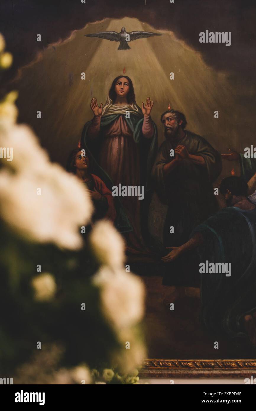 Blurred bouquet of white roses with a religious painting depicting the ...