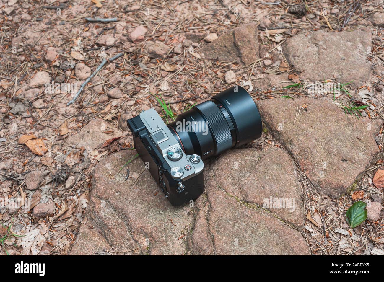 Sony A7c full frame camera with 85mm lens laying on rocky ground in the ...