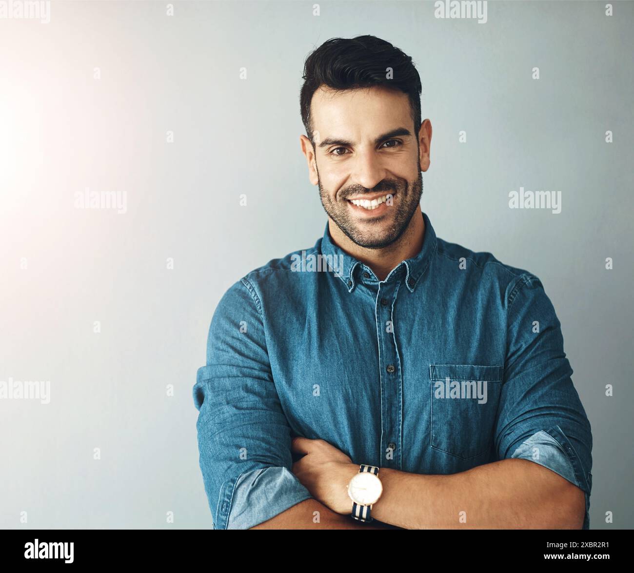 Business man, portrait and arms crossed on white wall background with confidence and smile for startup career. Face of a graphic designer or Mexican Stock Photo
