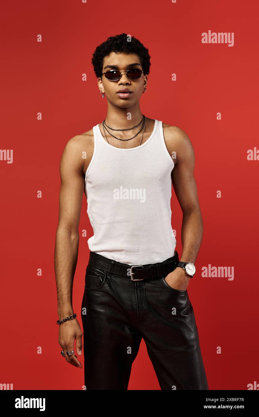 Handsome man in white tank top and leather pants with stylish ...