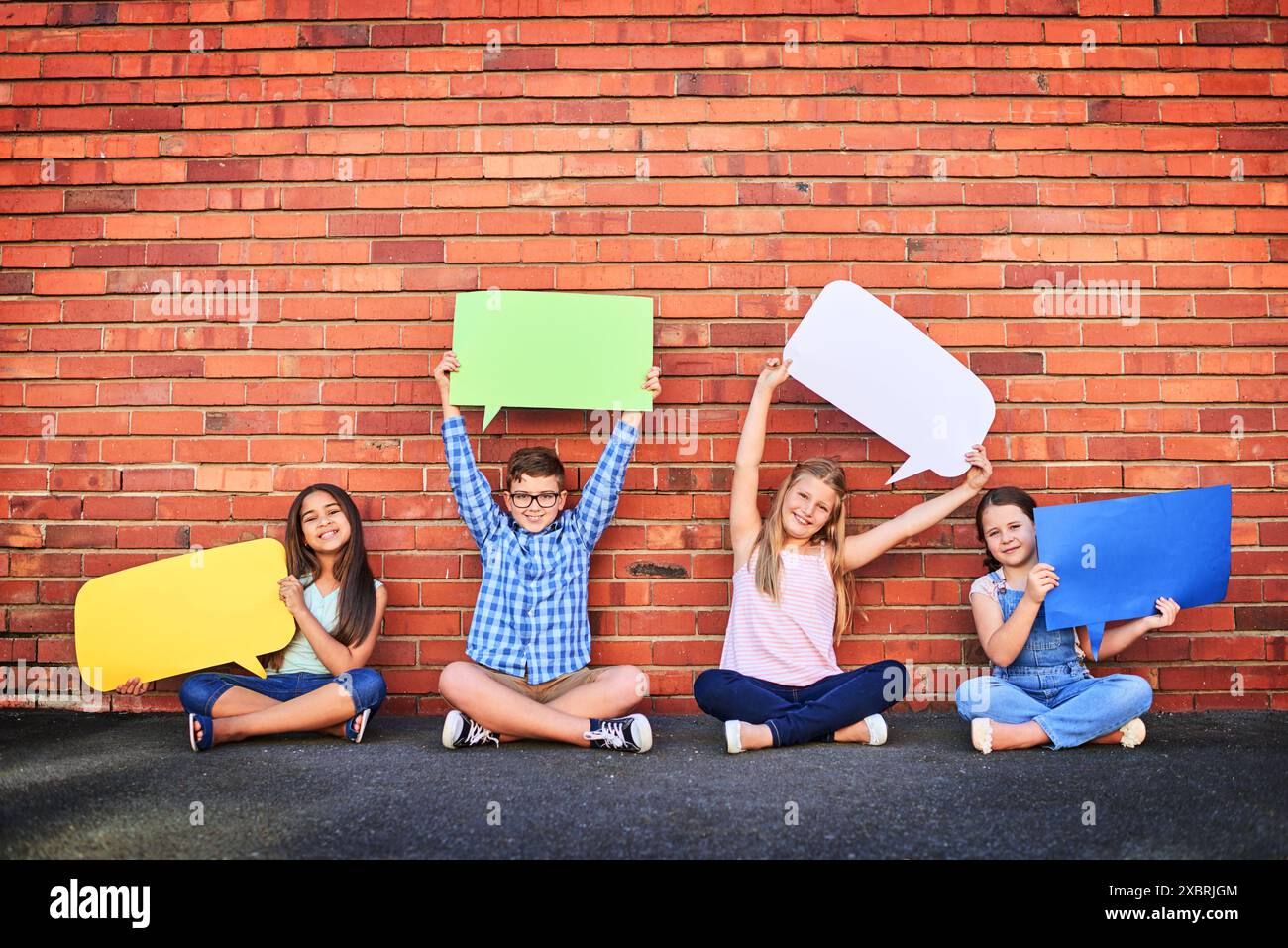 Kids, wall and happy in outdoor with speech bubble in colors for promotion and advertisement. People, gen z and portrait in smile with creativity for Stock Photo