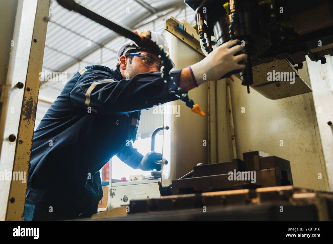 A mechanic is inspecting the oil level in the engine of a machine in a ...