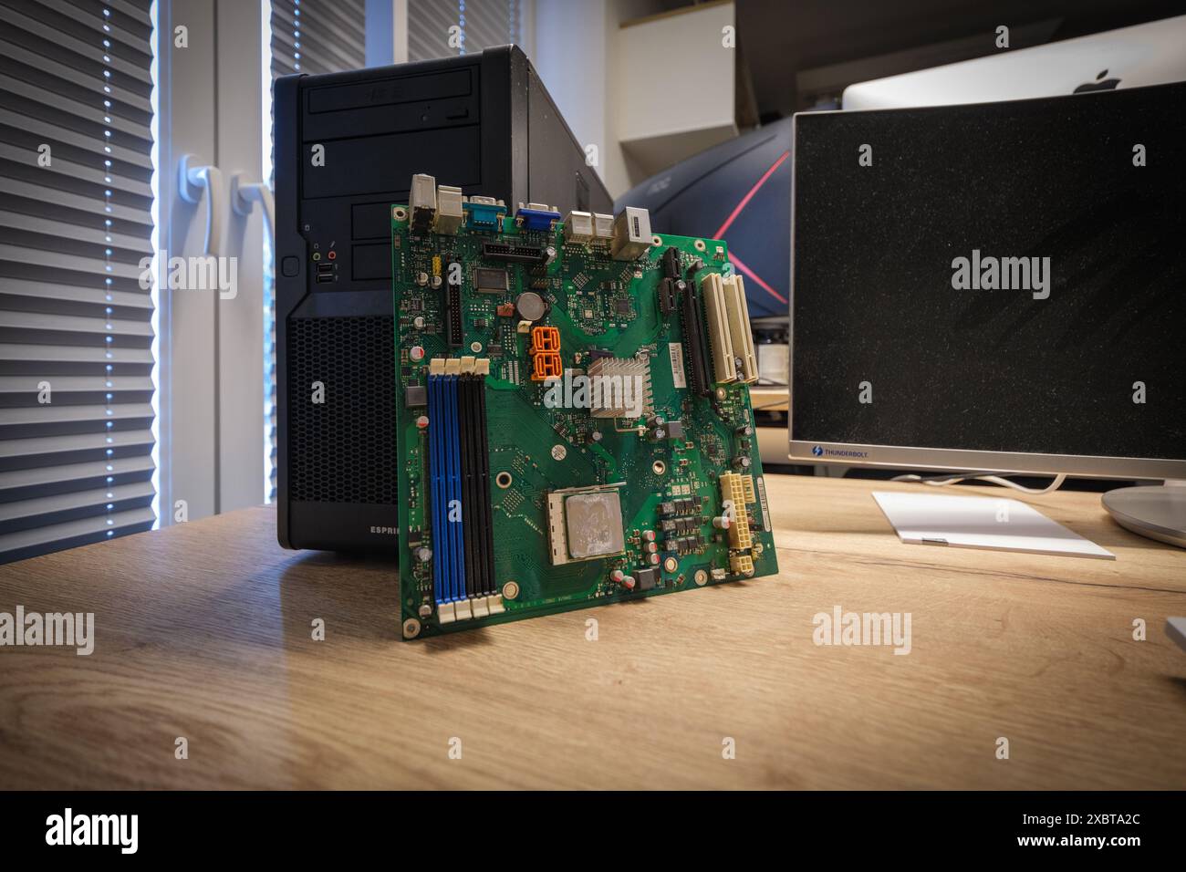 a computer mainboard is examined with a magnifying glass Stock Photo